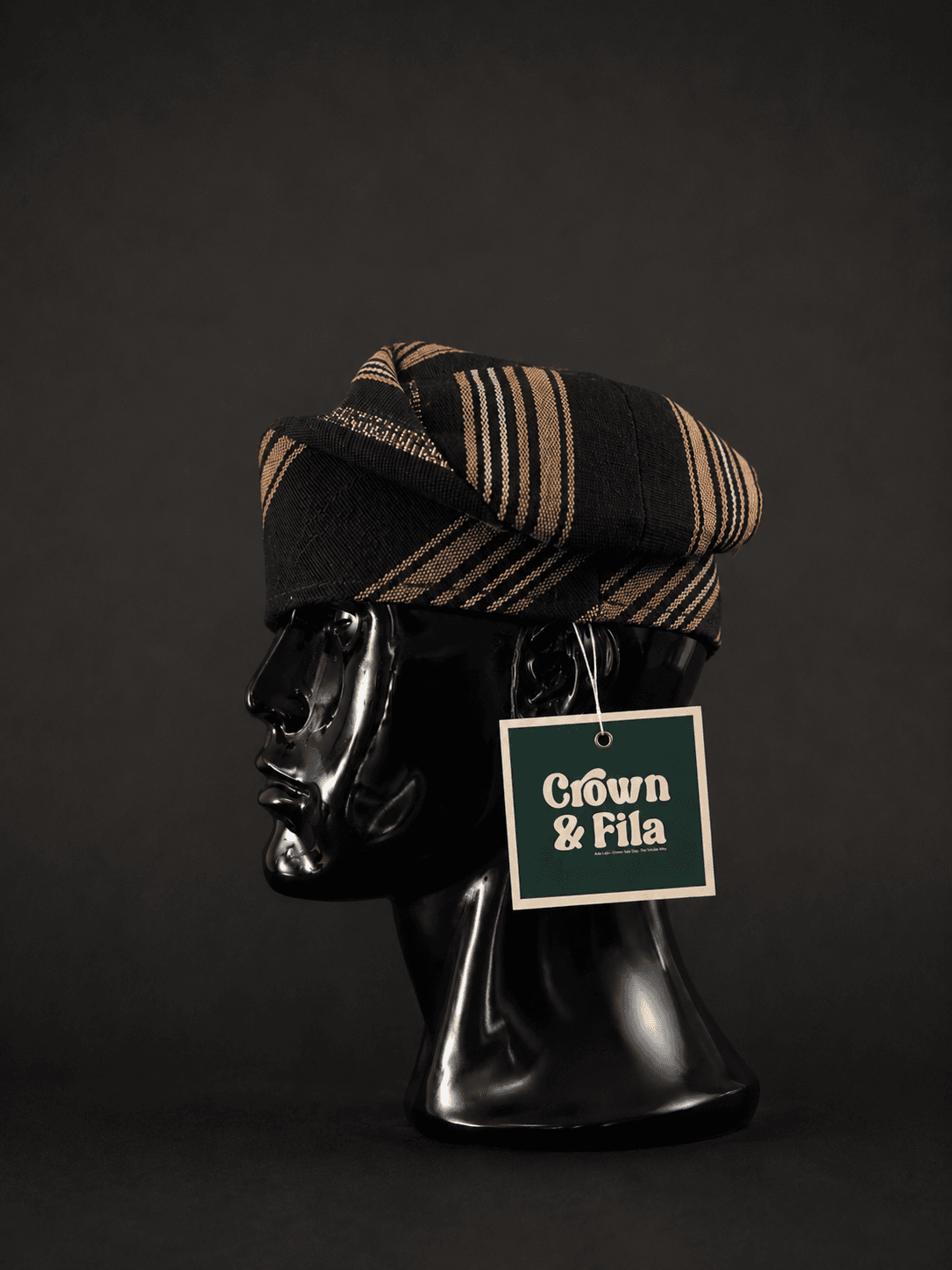 A hand-woven aso-oke cap, presented on a mannequin bust